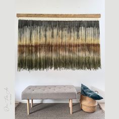 the wall hanging is decorated with fringes and wood frame, along with a bench