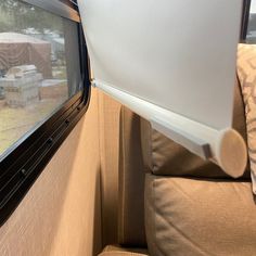 the inside of a camper with a window on it's side and a couch in front