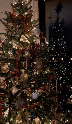 a christmas tree is decorated with gold, silver and red ornaments