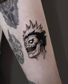 a man's arm with a tattoo on it that has a skull and demon head