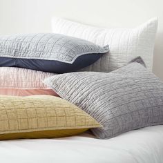 pillows stacked on top of each other on a bed