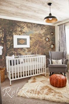 a baby's room with a white crib, gray chair and wallpaper