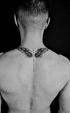 the back of a man's neck with wings on it