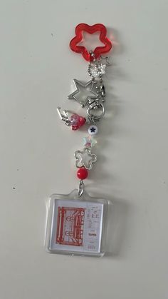 a red and white keychain with charms attached to it's back end