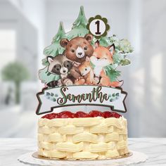 a cake with an animal themed topper on it and the number one for something