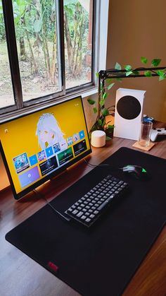 a computer desk with a keyboard, mouse and monitor on it next to a window