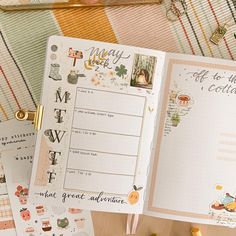 an open planner book sitting on top of a table next to other papers and magnets