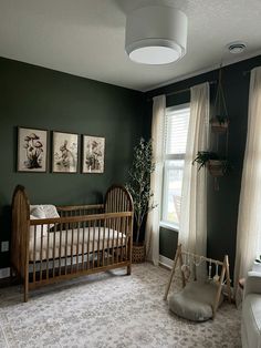 a baby's room with green walls, white curtains and a crib in the corner