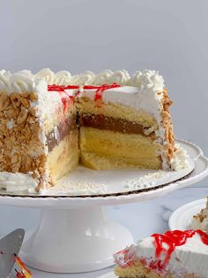 a cake with white frosting and red sprinkles sitting on a plate