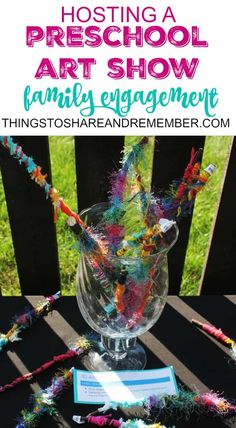 a glass vase filled with colorful streamers on top of a wooden table next to a sign