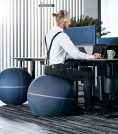 a man sitting at a desk on top of a ball