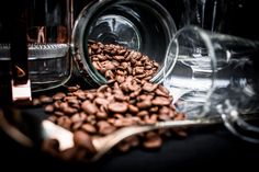 coffee beans are spilled out of glass containers