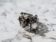 "AZAZEL 2 RING STORY Azazel (here spelled 'ăzā'zyēl) is born again in Iron Clan's collection with new face and ornament, Azazel was one of the chief Grigori, a group of fallen angels that became an evil spirit, specifically a demon of the second order, guardian of the goat. Handmade by Iron Clan Jewelry in Dec 2021, Released in Jan 2022. JEWELRY DETAILS: Metal: Available Casted into Pewter, White Brass, Brass and 925 Silver Weight: 17-19 g (depends on size) Great Handmade details Made-to-order ( Aztec Rings, Pewter Ring, Small Skull, White Brass, Jewelry Words, Rock N’roll, Rings Cool, Gifts For My Boyfriend, Skull Ring