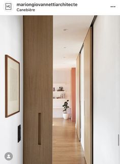 an open door leading to a hallway with wood floors and white walls in the background