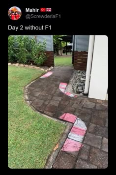 a brick walkway that has been painted with pink and white stripes on it, next to a