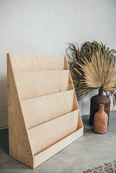 two vases sitting next to each other near a wooden stand with plants in it