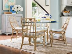 a dining room table with chairs and a glass top centerpiece in the middle of it