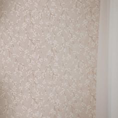 a white toilet sitting in a bathroom next to a wall papered with small flowers