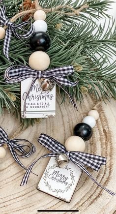 christmas ornaments are hanging from a tree with black and white ribbons on them, along with a tag that says merry christmas