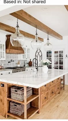 a large kitchen island with lots of drawers and lights hanging from it's ceiling