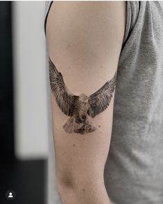 a man with a tattoo on his arm has an eagle in the middle of his arm