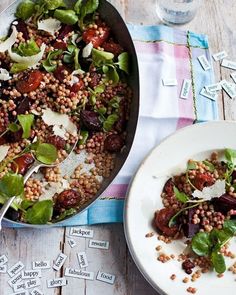 a pan filled with food next to a bowl of salad on top of a table