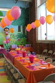 a room filled with lots of tables covered in orange and pink balloons