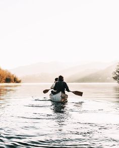 two people in a canoe paddling on the water