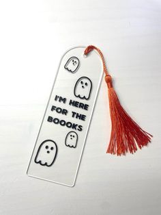 a bookmark that has been decorated with ghost faces and the words i'm here for the books