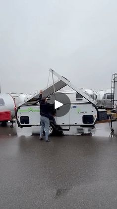 a man standing next to an rv in the rain