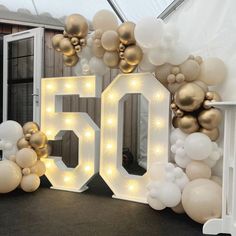 the 50th birthday sign is surrounded by balloons and streamers in gold, white and silver colors