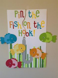 a sign that says pin the fish on the hook with some cut outs attached to it