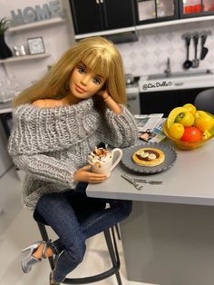 a barbie doll sitting at a kitchen table with food