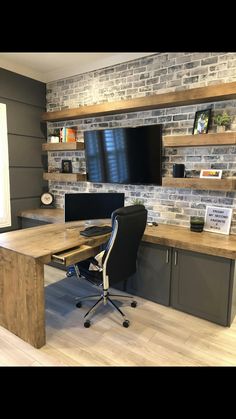 a desk with a monitor, keyboard and chair in front of a wall mounted tv