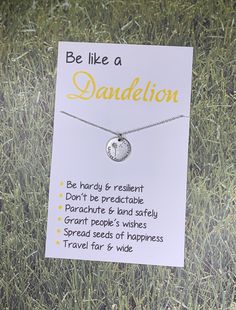 a card that says, be like a dandelion on it in front of some grass