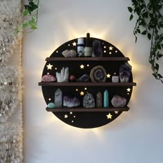 a wall mounted shelf filled with rocks and candles