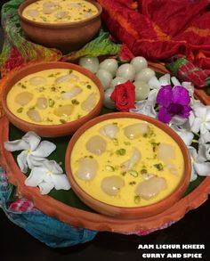 two bowls filled with food sitting on top of a table next to flowers and eggs