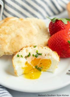 an egg and some bread on a plate with strawberries