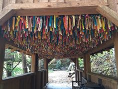 colorful ribbons hang from the roof of a wooden structure