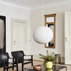 a living room filled with furniture and a white ball hanging from the ceiling