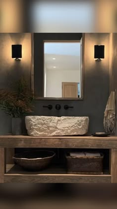 a bathroom with a sink, mirror and two baskets on the counter top in front of it