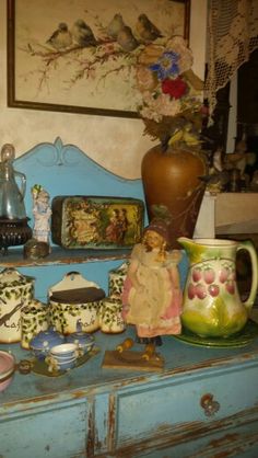 a blue dresser topped with vases and figurines