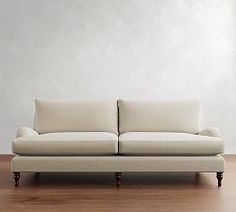 a white couch sitting on top of a hard wood floor