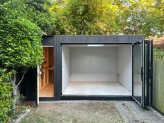 a small black shed with an open door