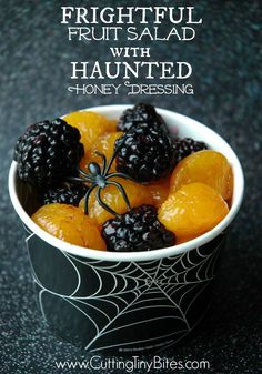 a bowl filled with fruit sitting on top of a black countertop next to a spider web