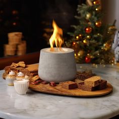 a lit candle sitting on top of a table next to crackers and marshmallows