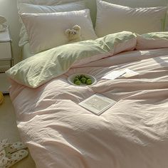 an unmade bed with pink sheets and pillows on the floor next to a stuffed animal