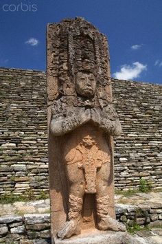 an ancient statue is in front of a stone structure with steps leading up to it