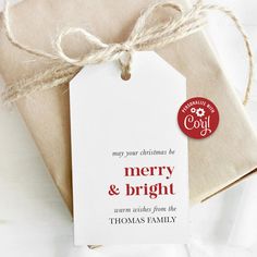 a christmas gift tag is tied up with twine on top of a white envelope