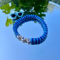 a bracelet with beads and sunglasses on top of a table